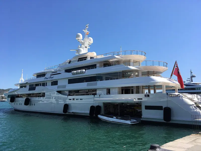 Alongside in Ibiza in August 2017, showing the full five-deck stack, the helipad structure forward and the aft beach-club doors open at the waterline.