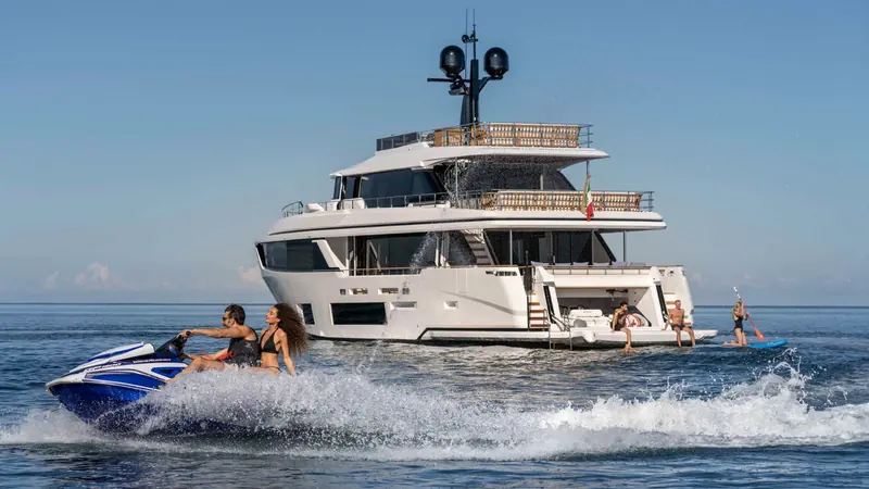 Guests on jet skis alongside an anchored Navetta 30.