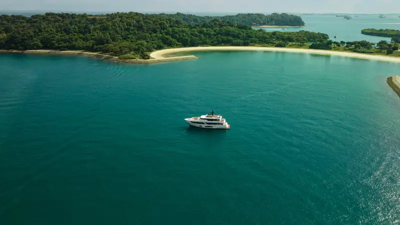 A Navetta 30 anchored off an island beach, seen from the air.