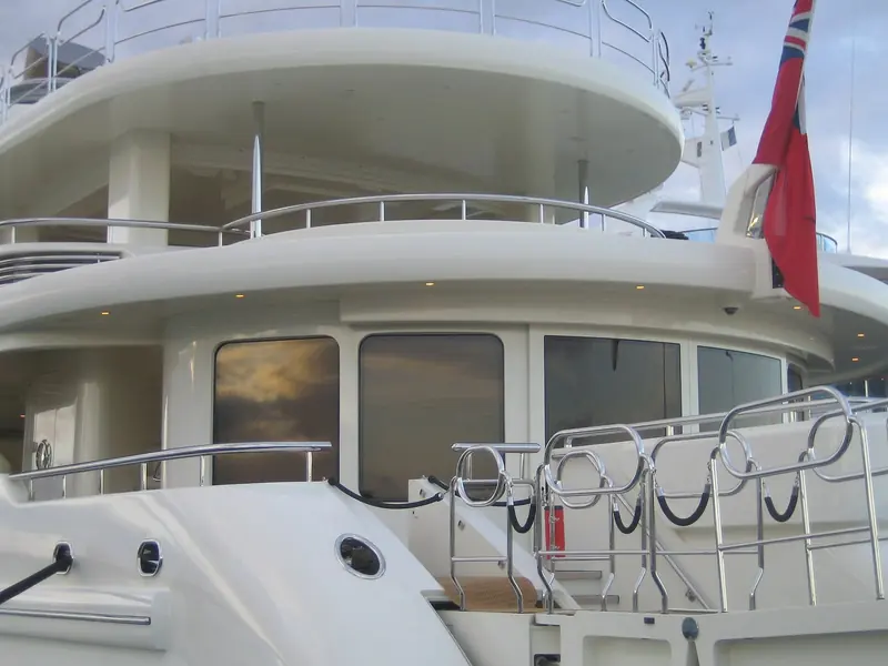 Upper-deck railing and the crew's working deck aft of the bridge, with the ensign at half-mast height on the flag halyard - detail rarely visible in a builder's own marketing photography.