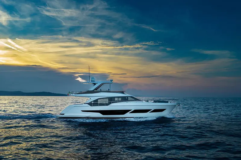 At anchor at sunset, the 670's flybridge hardtop and the sheer of the flybridge-model profile against the sky.