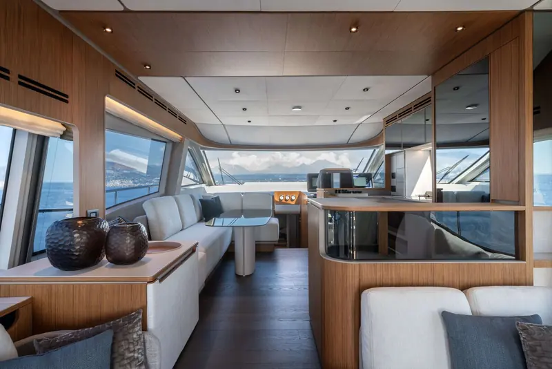 The main-deck saloon looking aft, teak joinery and the galley-up layout that keeps the helm and saloon on one level.