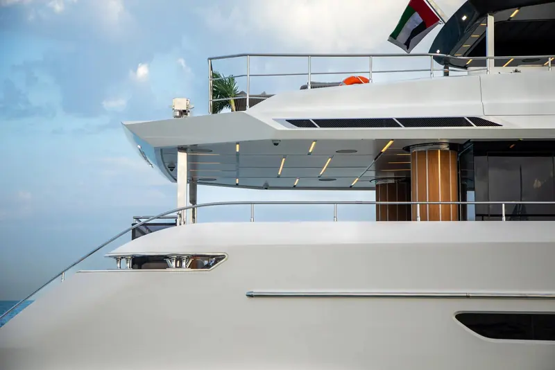 The foredeck sunpad and flybridge overhang show the compact bow layout Gulf Craft uses to keep deck space usable on a sub-115-foot hull.