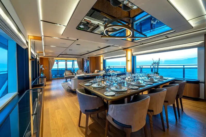 A skylit dining area seats eight under glass panels set into the deck above, bringing daylight into the main saloon without sacrificing the deck space overhead.