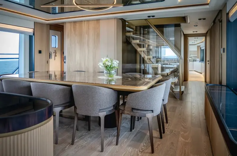 A second dining nook finished in warmer wood tones, staircase to the lower deck rising just behind it.