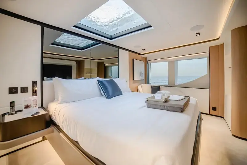 Owner's cabin with its own overhead skylight and a built-in vanity desk against the hull side, twin bedside night tables either side of the berth.