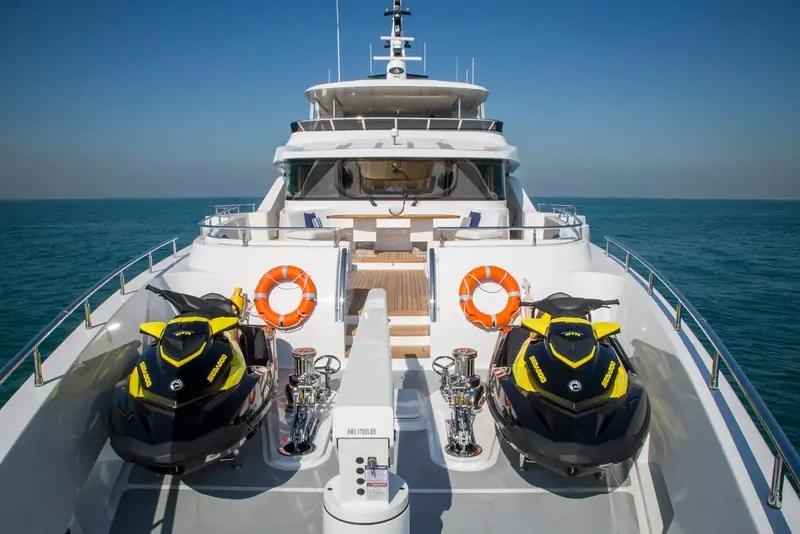 A forward garage on the bow stows two jet skis behind their own dedicated crane, freeing the aft deck for guest use rather than toy storage.