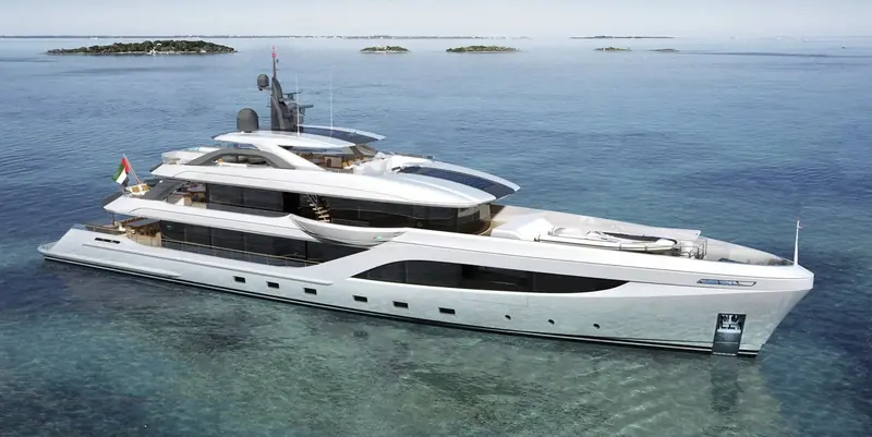 At anchor over a shallow reef, tender stowed under cover on the foredeck - the hull is painted, not rendered, evidence this is the delivered first unit rather than a concept image.