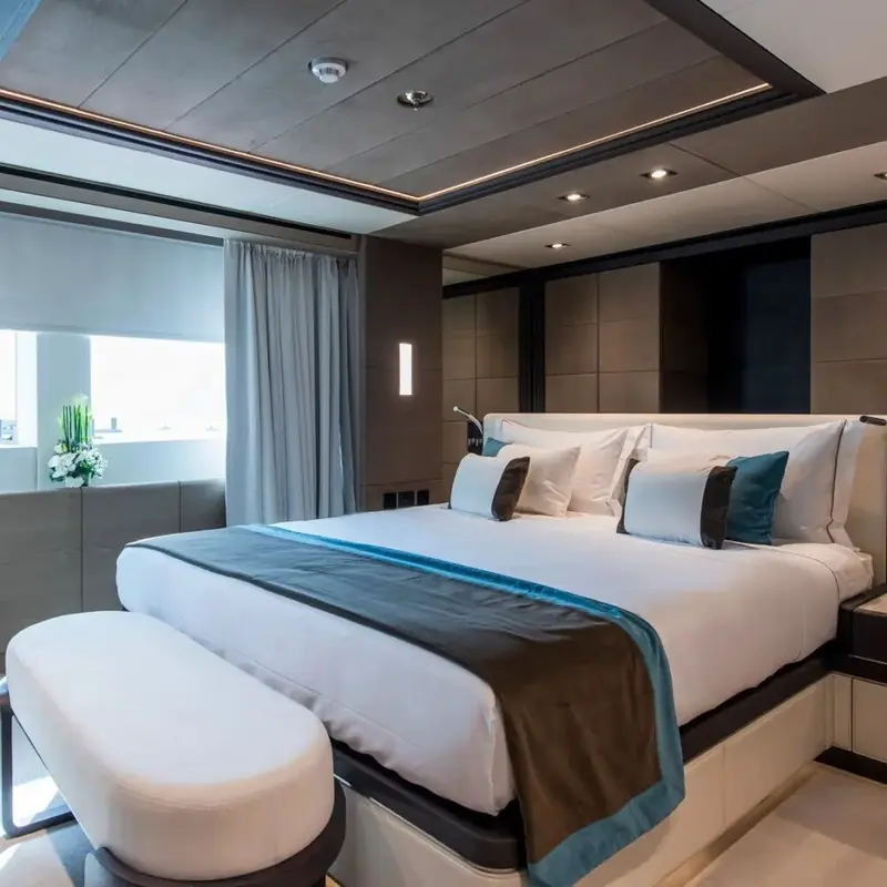 A guest stateroom finished in dark wood and teal accents, one of the cabins Gulf Craft fits below the main deck to keep the owner's suite forward and private.