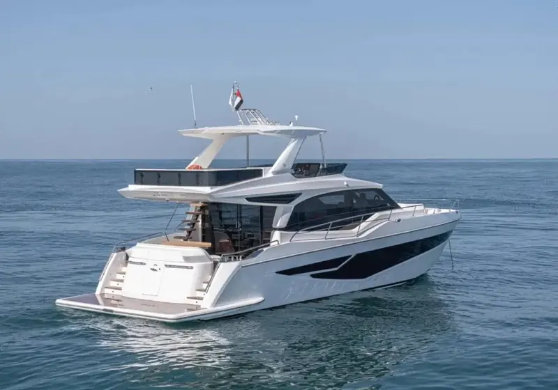 Under way from astern, the flybridge hardtop and radar arch visible above a wide, symmetrical planing wake.