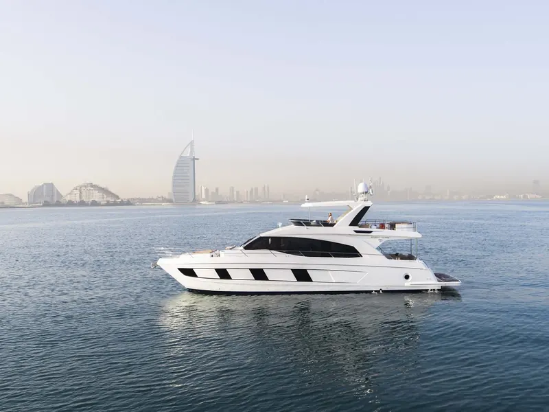 Passing the Burj Al Arab, the black hull-side striping is the visual signature Gulf Craft carries across the Majesty line from the 62 up to the 175 flagship.