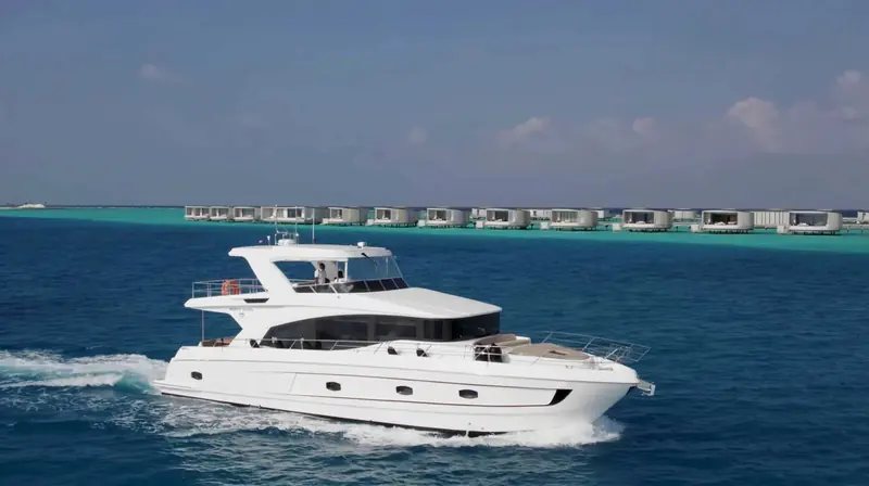 Cruising past the Ritz-Carlton Maldives overwater villas, the kind of shallow-draft charter ground this size of Majesty is built to work in.