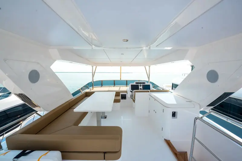 The flybridge dining and lounge area runs the full beam under an open sky, the main entertaining deck on a boat this size rather than an owner's private retreat.
