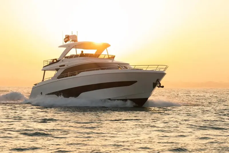Cruising at speed into a low sun, the tuck of the transom and the raked windscreen both picked out by the backlight.