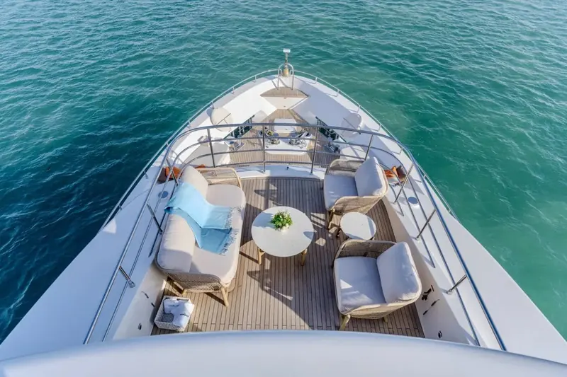 Looking forward along the foredeck lounge from the bow rail, city skyline on the horizon beyond the pulpit.