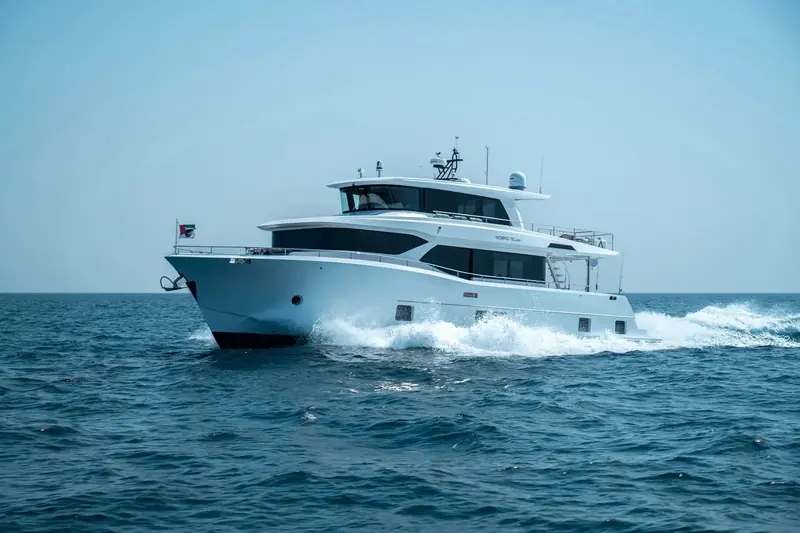 A Nomad 70 SUV runs in open water off the UAE coast, the raised pilothouse and near-plumb bow that give the line its profile clearly visible from the bow quarter.