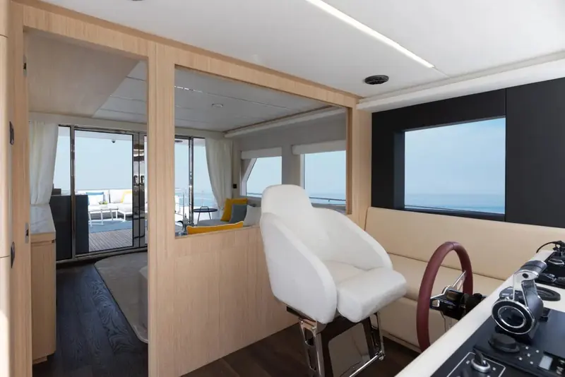 The helm station, single seat and side door to the deck, in the raised wheelhouse that separates the Nomad line from a flybridge cruiser of the same length.
