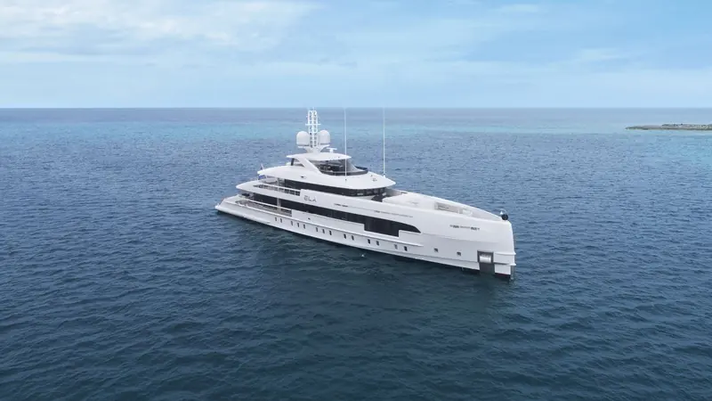Heesen's 50m Aluminium FDHF at anchor over shallow tropical water, the fast-displacement hull form that lets the yard's aluminium range cruise faster than a comparable steel hull on the same power.