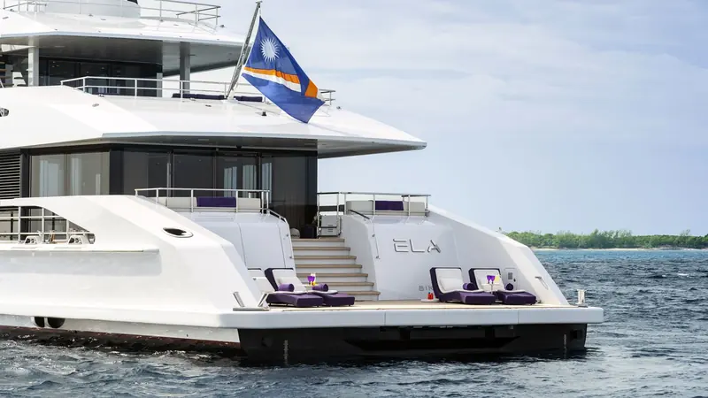 The transom of the hull named ELA, with a full-beam swim platform and steps that turn the aft deck into direct water access at anchor.
