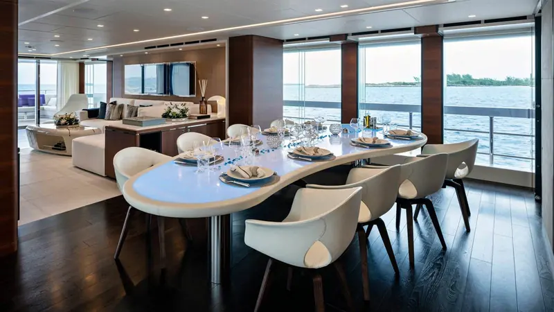 A more formal dining table for eight is set apart from the main lounge, giving the boat two distinct entertaining spaces on the same deck.