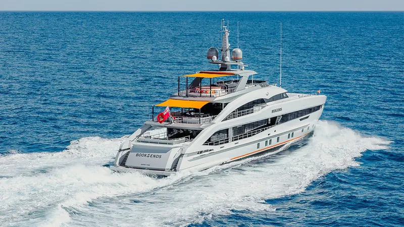 Book Ends under way off the coast, her transom lettered with home port George Town, Cayman Islands, where she is registered.