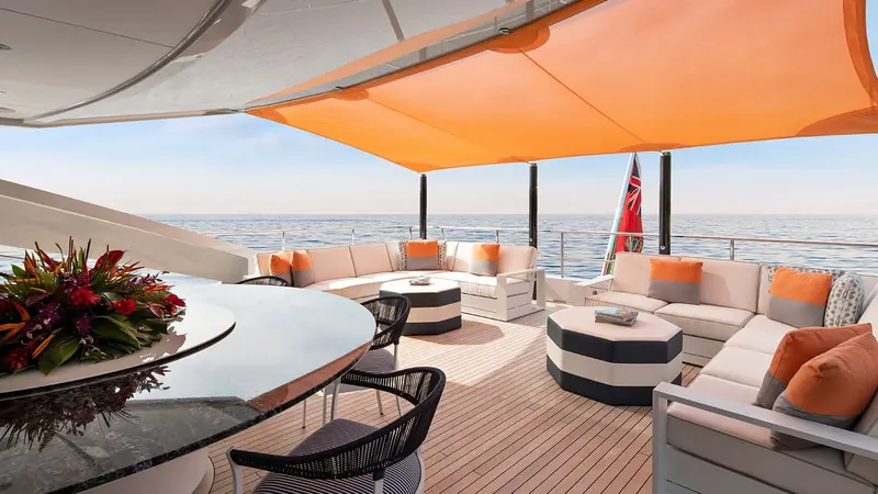 Aft deck seating steps down toward the water, with the tender garage doors visible either side of the swim platform.