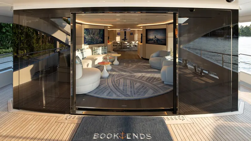 The pivoting glass door at the main-deck aft entrance, with the Book Ends nameplate set into the teak threshold.