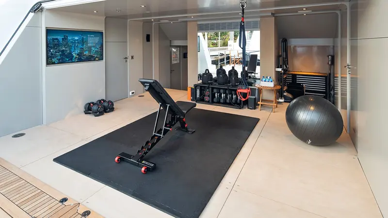 A dedicated onboard gym, fitted out with free weights and a stability ball rather than left as spare cabin space.