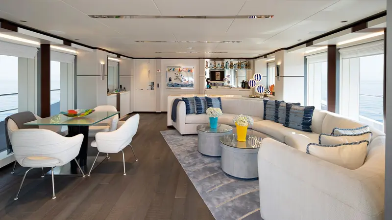 The dining and lounge area opens to full-height glazing, keeping the water in view from the table.