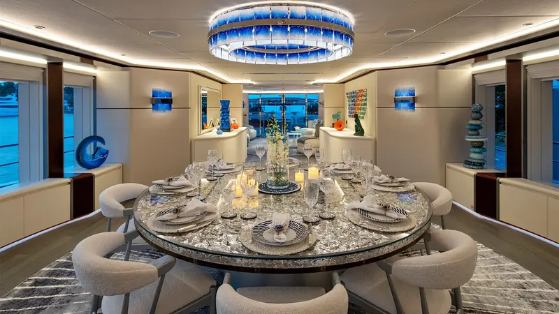 Formal dining for the full guest complement, set beneath a ring of pendant lighting.