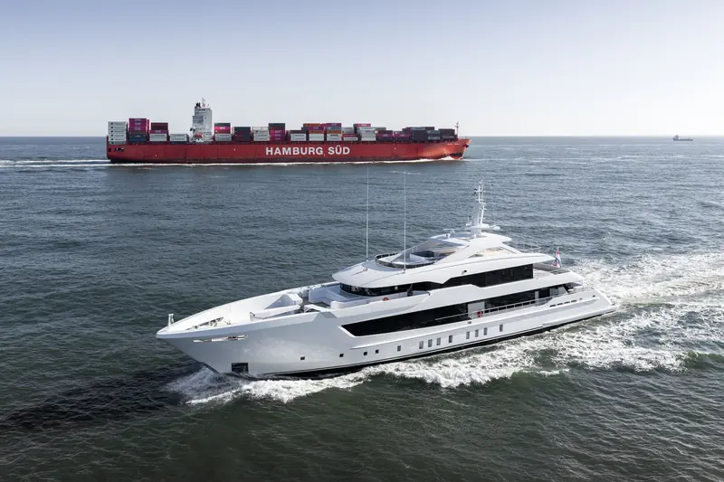 Pa'lante passes a Hamburg Sud container ship off the Dutch coast, a reminder that Heesen's Oss yard sits well inland up the river system rather than on open water.