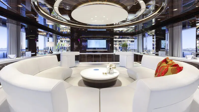 A circular lounge sits under a domed skylight in the main saloon, built as a single statement piece rather than broken into separate seating groups.