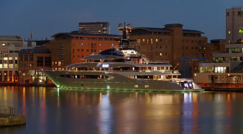 Kismet lit up at night on the City Canal in London's Docklands, with the Museum of London Docklands warehouses behind her.