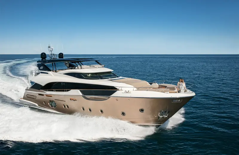 Mia running at speed, owners on the foredeck, showing the raised pilothouse and full-length side decks Nuvolari Lenard carried down from the MCY 105.