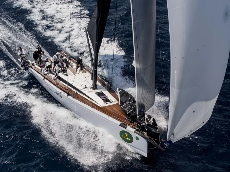 A ClubSwan 50 crew trimming under spinnaker in close company with a rival.