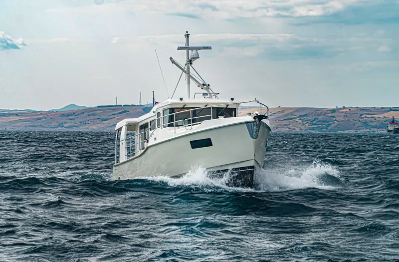 The Nordhavn 41 under way, showing the full walkaround side decks that let a shorthanded crew tie up without crossing the foredeck.