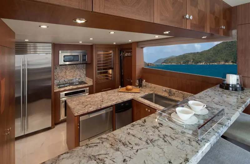 The galley, with full-size stainless appliances, stone counters and a window framing a real anchorage outside.