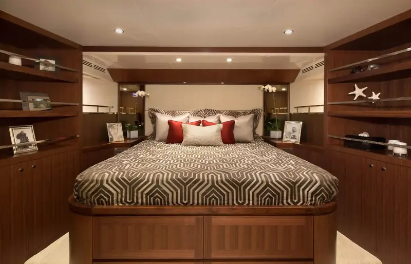 The full-beam master stateroom, centerline berth flanked by built-in cabinetry and personal photographs.