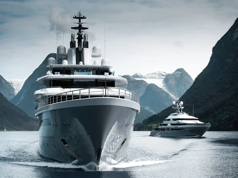 Oceanco's own concept rendering of Esquel running bow-on into a fjord, escorted by a support tender - Esquel exists only as this design, with no hull yet built.
