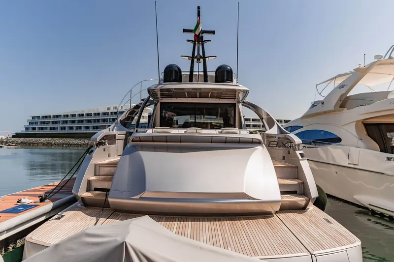 Stern-on at the dock, tender garage doors closed and the 8X badge visible either side of the swim platform.