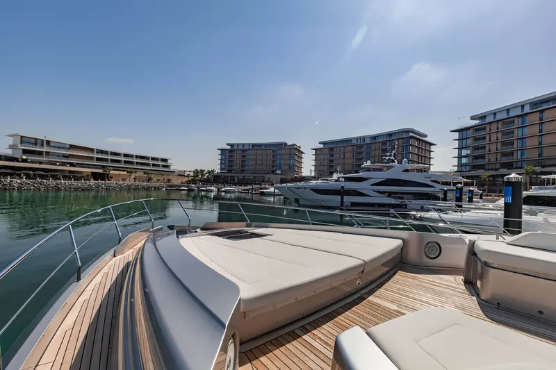 Foredeck sunpad and bow rail, shot from the tender garage looking forward along the full run of the deck.