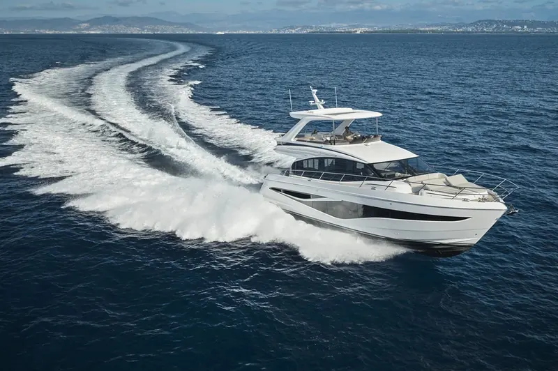 The F58 carving a hard turn off the French Riviera, twin wakes curling back on themselves - a sea trial shot, not a static marina pose.