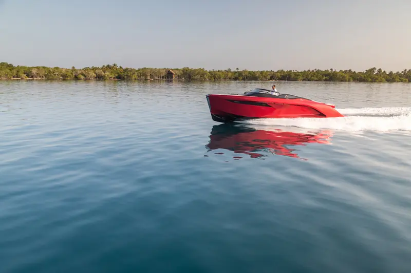 The R35's full profile at low speed on flat water, showing the Pininfarina-designed sheer line and blacked-out hull window.
