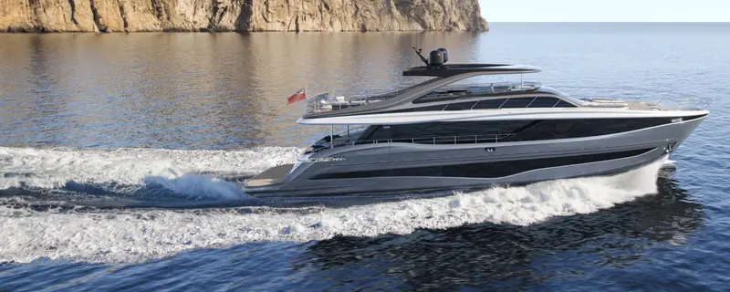 Running past a Mediterranean headland; the Y95's dark hull glazing and flybridge overhang are shared with the smaller Y-range boats scaled up to almost 29 metres.