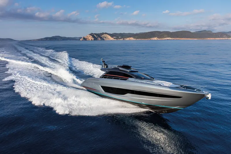 Underway off Ibiza, the twin MAN V12s push the hull onto a clean planing attitude, throwing a wide double wake typical of the boat's sports pace.