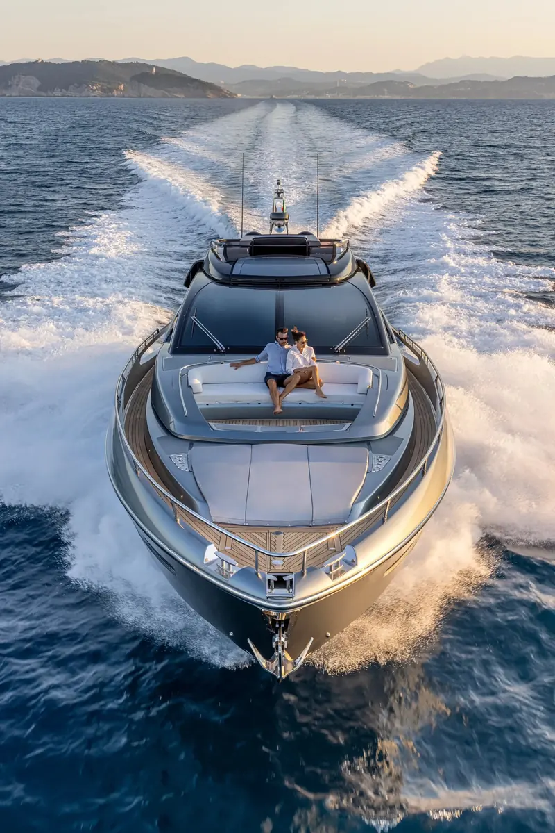 Bow-on running shot showing the full beam of the foredeck sunbathing area and the sheer of the hull.