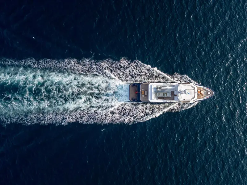 An overhead pass shows the full deck plan underway, from the foredeck tender stowage to the transom swim platform