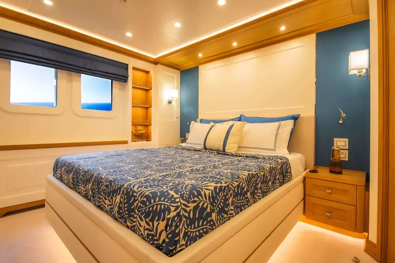 A second guest cabin aboard Seven Seas, with sea-view portholes and a built-in display shelf