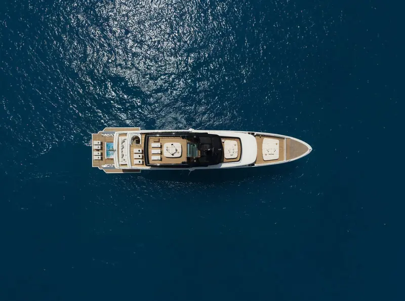A directly overhead shot showing the yacht's beam and the layout of the foredeck lounge.