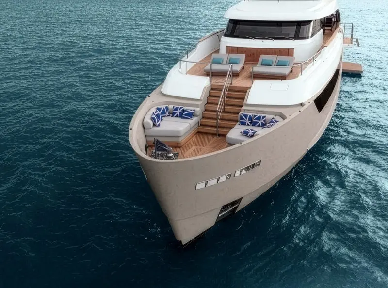 Looking aft over the flybridge and swim platform reveals how much open deck the hull's volume buys: two separate lounging areas plus a full-width aft terrace.